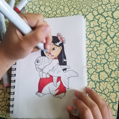 Person drawing a girl holding a stuffed fish with markers